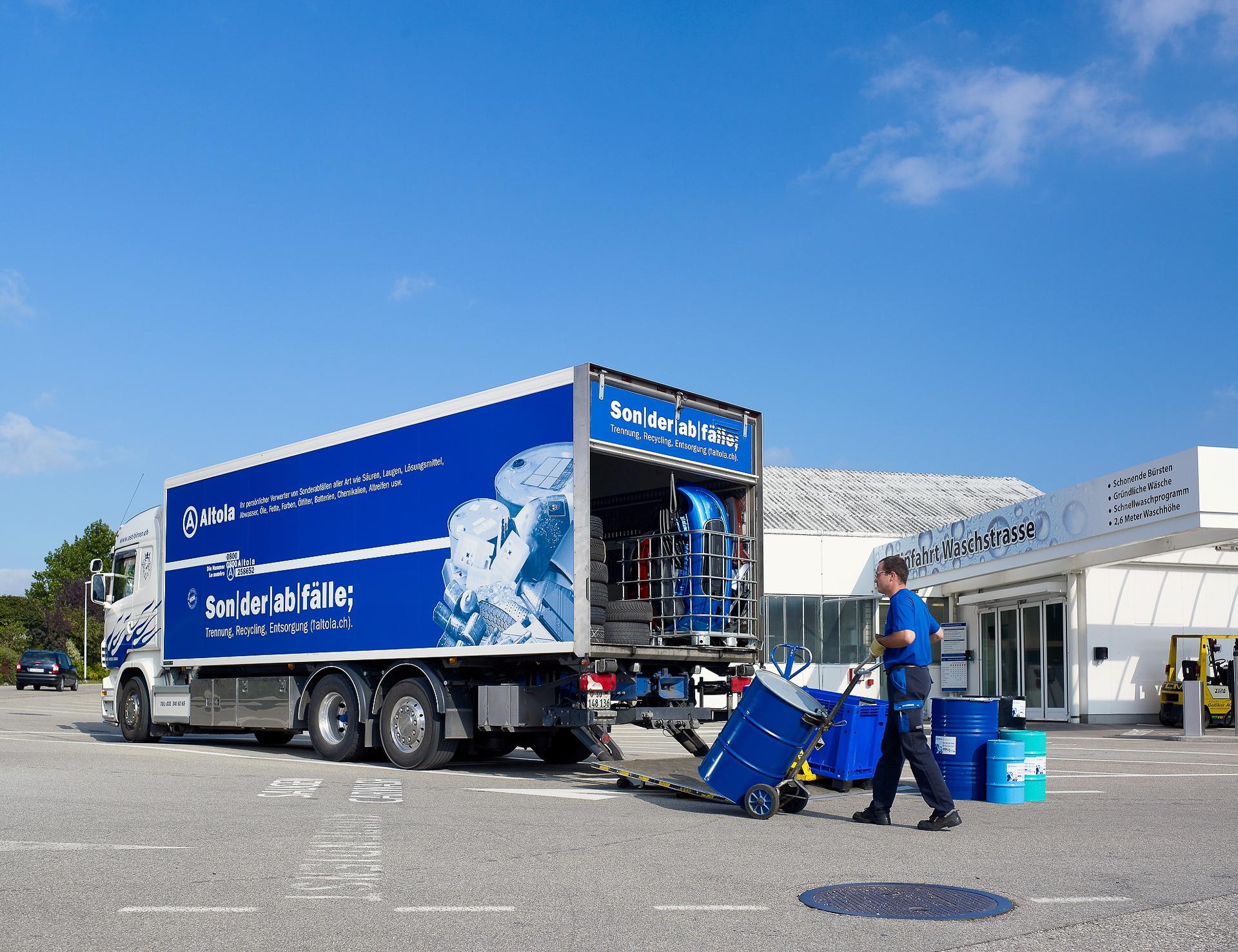 Der Lastwagen von Altola wird mit Garage Güter befüllt. Man sieht eine Abfallabholung bei einer Garage.