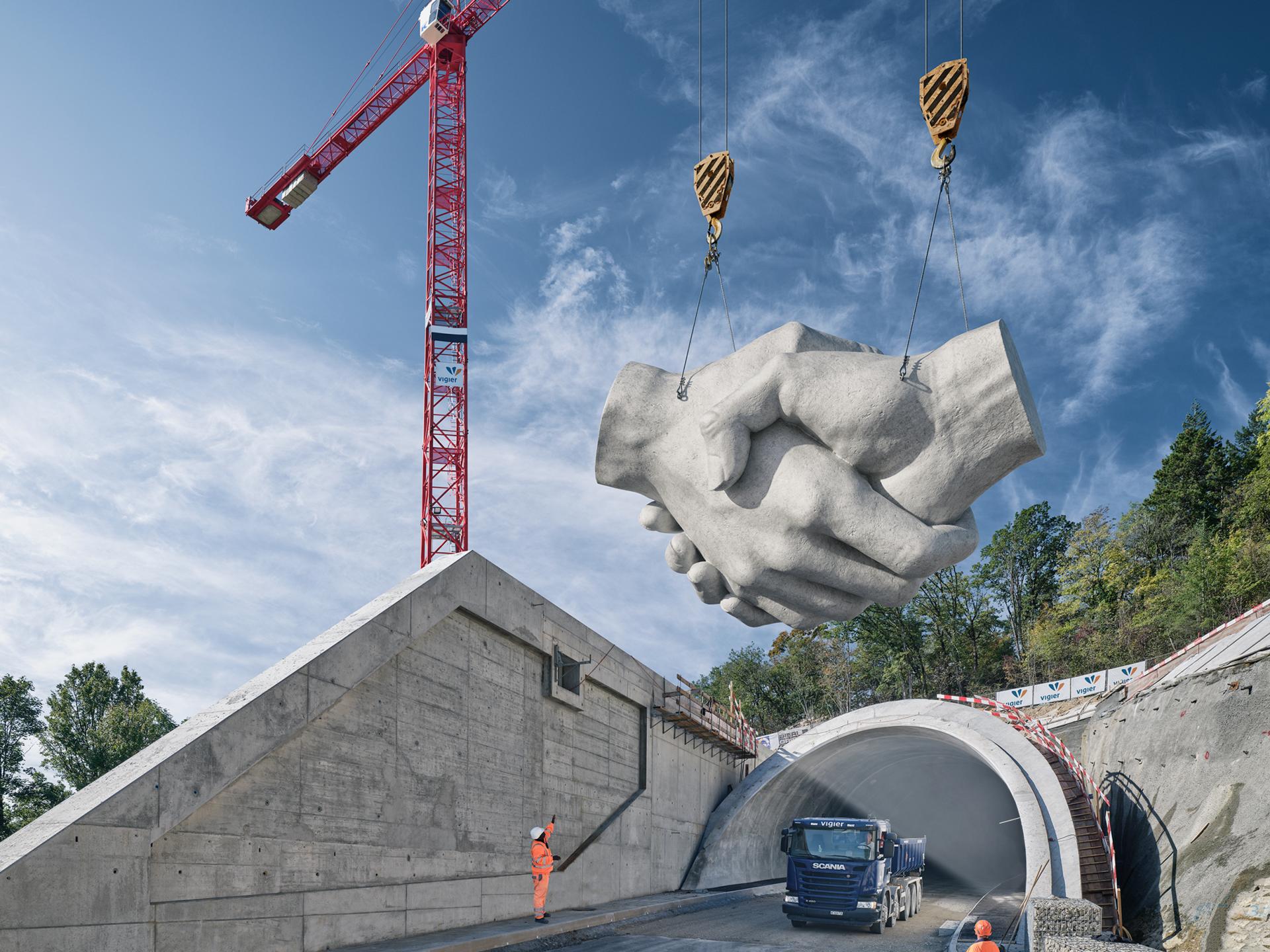 Das Keyvisual von Vigier zeigt eine Betonskulptur eines Handshakes. Die Skulptur wird von einem Kran angehoben.